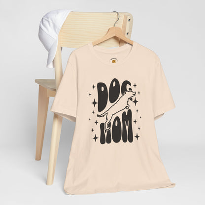 Soft cream t-shirt with 'Dog Mom' graphic on a wooden chair against a white background