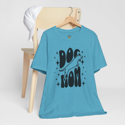 Blue t-shirt with 'Dog Mom' text on a wooden chair against a white background