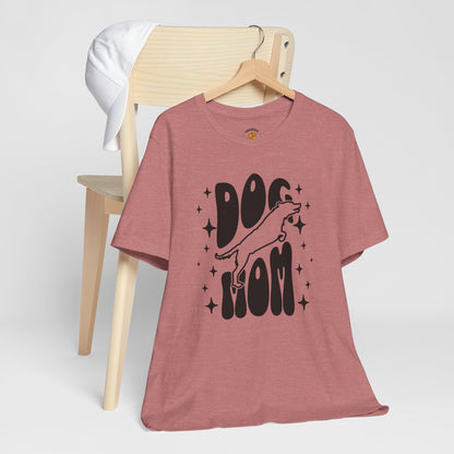 Pink t-shirt with 'Dog Mom' graphic on a wooden chair against a white background