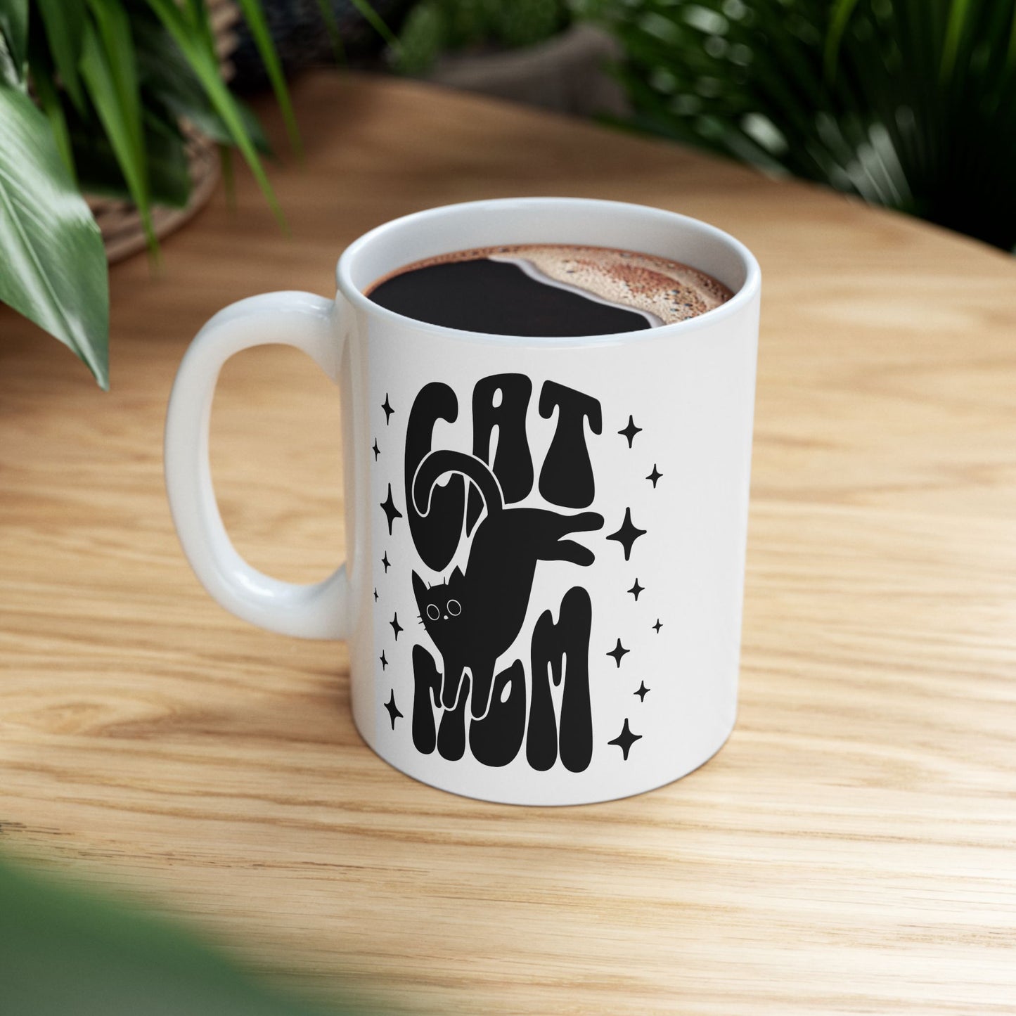 Cat Mom mug 11oz close-up — glossy white ceramic with black lettering and sparkling star accents
