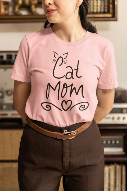 Woman wearing pink Cat Mom t-shirt with handwritten design and heart doodles
