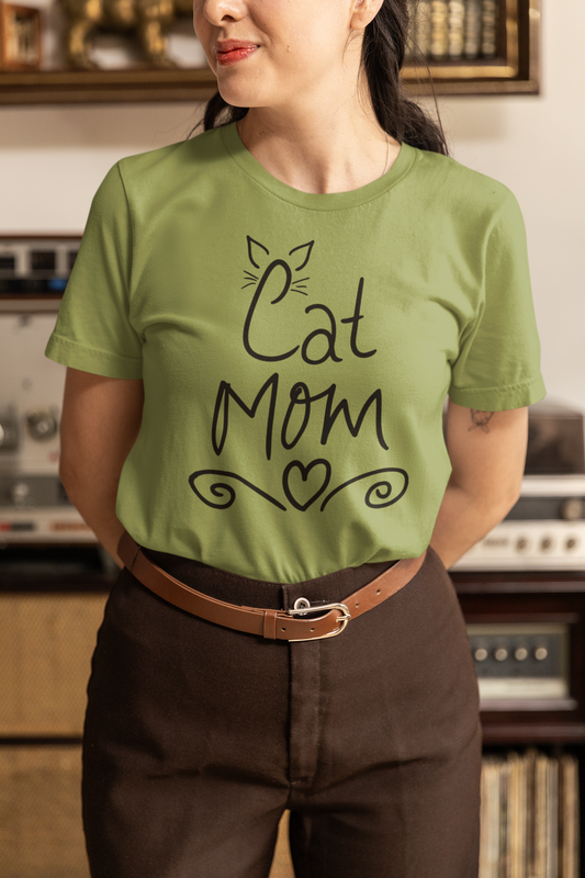 Woman wearing heather green Cat Mom t-shirt with handwritten design and heart doodles.