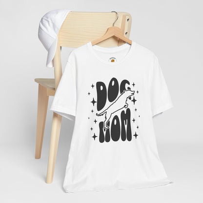 White t-shirt with 'Dog Mom' graphic on a wooden chair against a white background